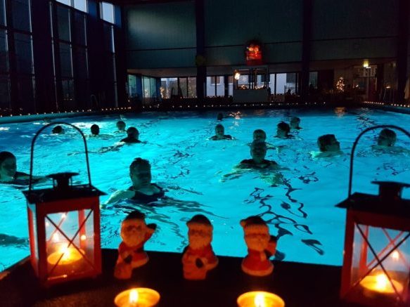 Goboprojektor zeigt Wellness-Logo auf Außenwand bei Dämmerung