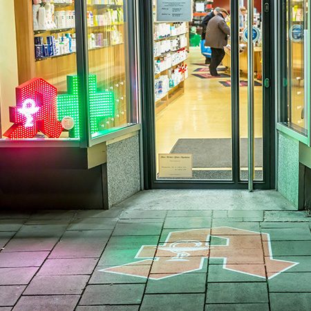 Goboprojektor zeigt „Masken erhältlich“ auf Eingangsboden