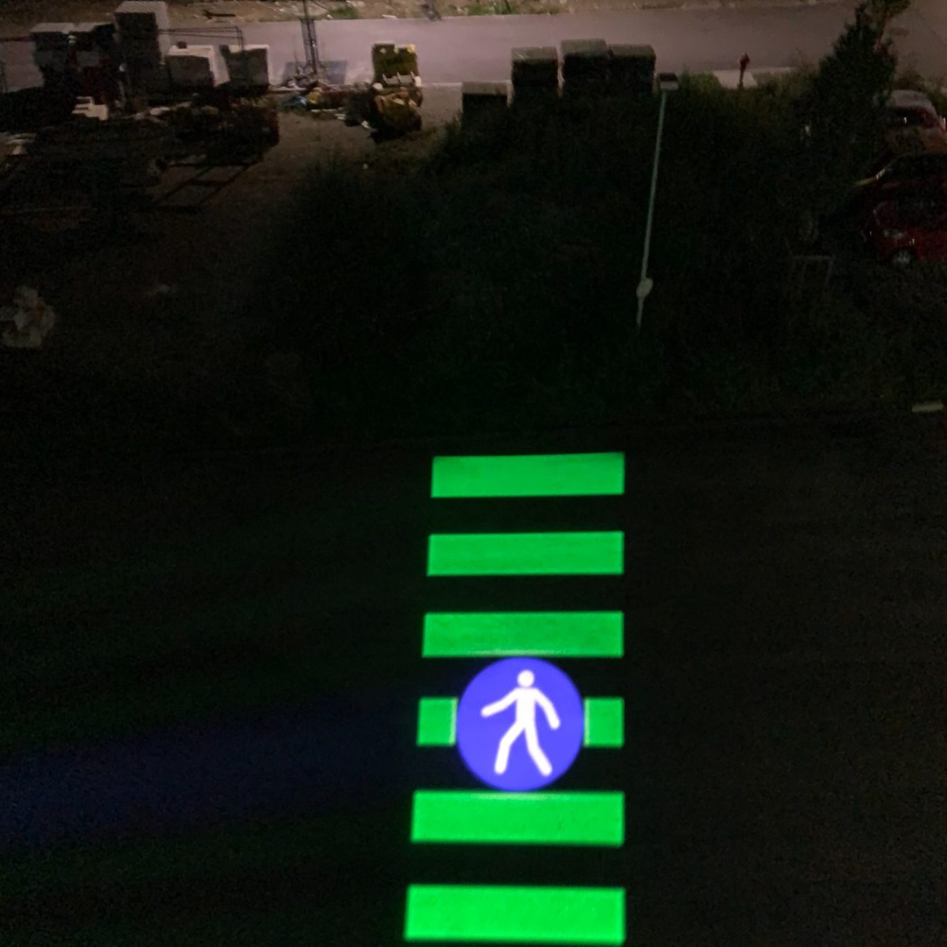 Projiziertes Fußgängersymbol mit Gobo Projektor am Zebrastreifen
