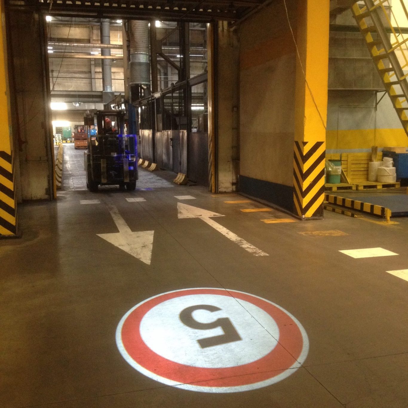 Gobo Projektion eines Gefahrzeichens auf Industrieweg