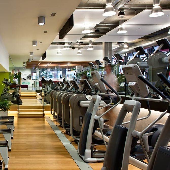 Goboprojektor projiziert Logo Gobo an Spiegelwand im Fitnessraum